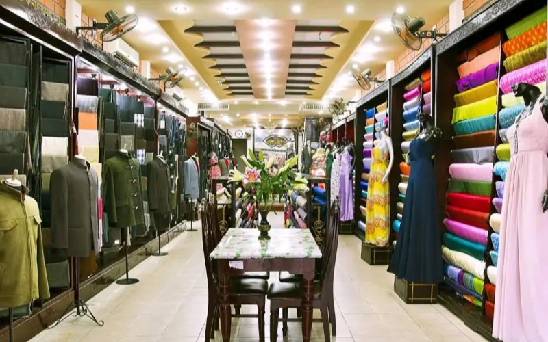 A tailor at Bao Khanh Silk takes precise measurements for a custom-made outfit
