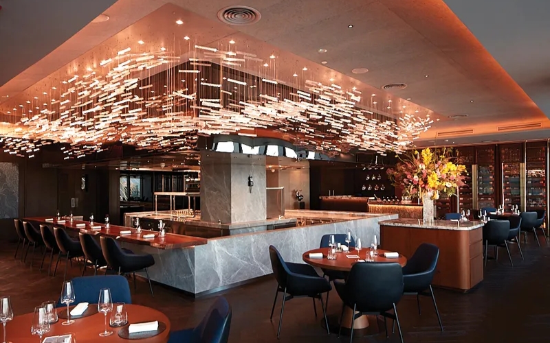 Interior view of Akuna Saigon, featuring a sleek open kitchen, warm lighting, and elegant place
