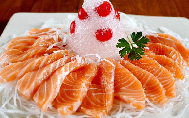 Fresh salmon slices served sashimi-style on shredded vegetables with ice, a specialty from Sapa, northern Vietnam.