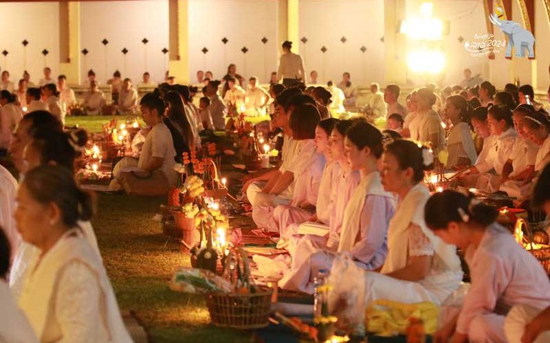 Candlelight procession at That Luang Festival in Laos with devotees holding candles and wax castles.