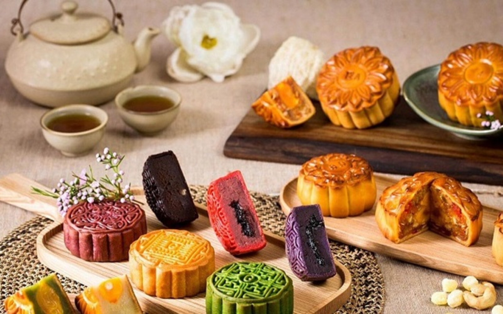 Assorted modern Vietnamese mooncakes in flavors like green tea, durian, and chocolate, beautifully displayed in a gift box.