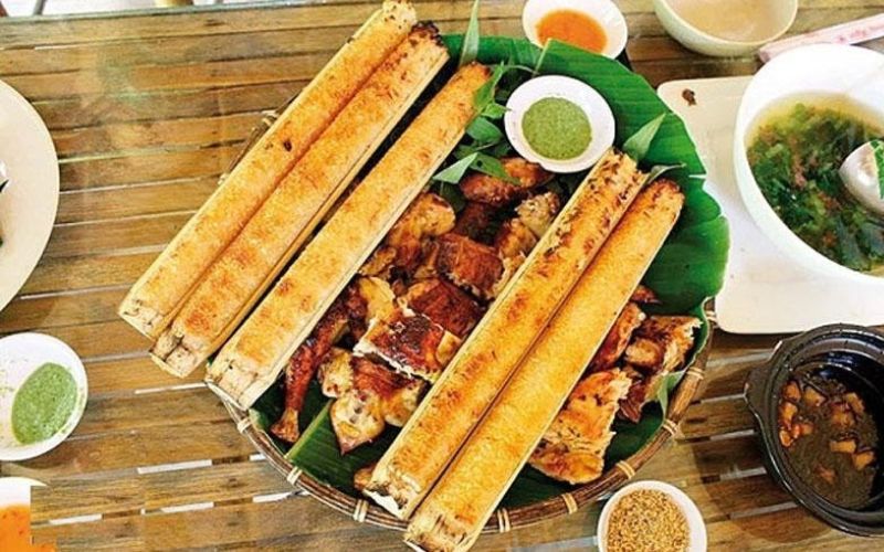Traditional Vietnamese meal with grilled stream fish and bamboo-tube sticky rice (Com Lam), served with dipping sauces and vegetable soup