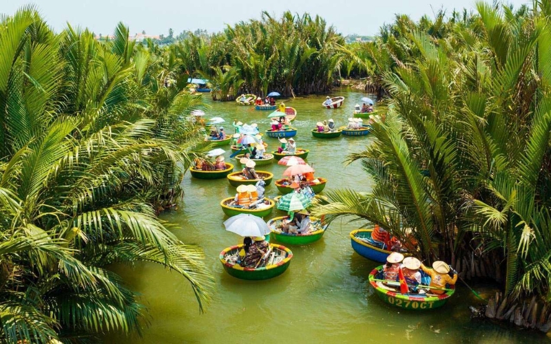 Basket boats cruising through the lush coconut palm waterways of Cam Thanh Coconut Village in Hoi An, Vietnam.