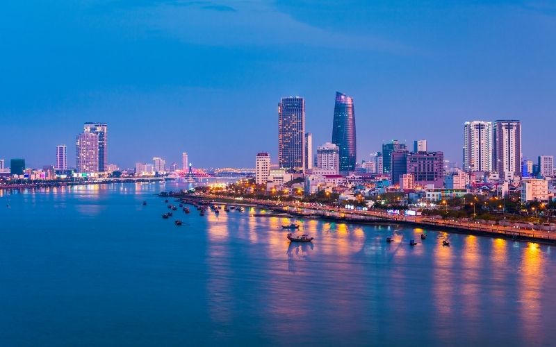Da Nang skyline at dusk with city lights reflecting on the Han River, showcasing the beauty of Vietnam’s coastal city