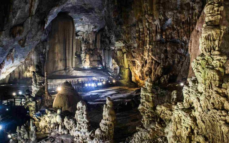 Interior of Dark Cave in Phong Nha-Ke Bang showing rugged limestone formations, dim lighting, and wooden walkways inside the cave