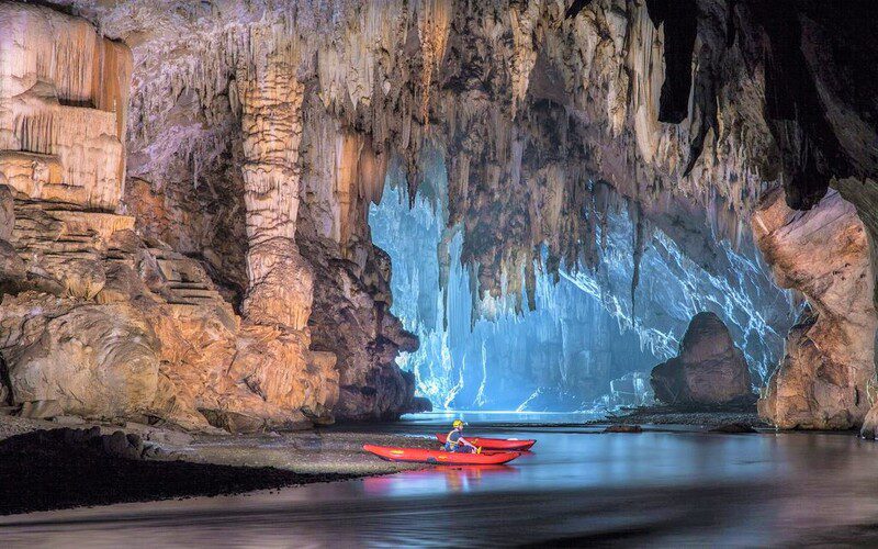 Explore Tham Lod cave system by boat