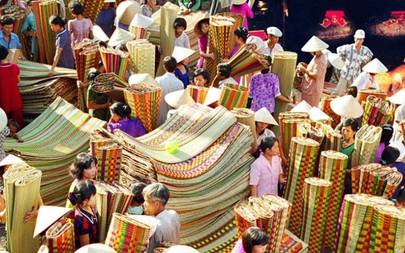 Early morning bustle at Ban Thach Village Market, where vibrant handmade mats are traded at dawn