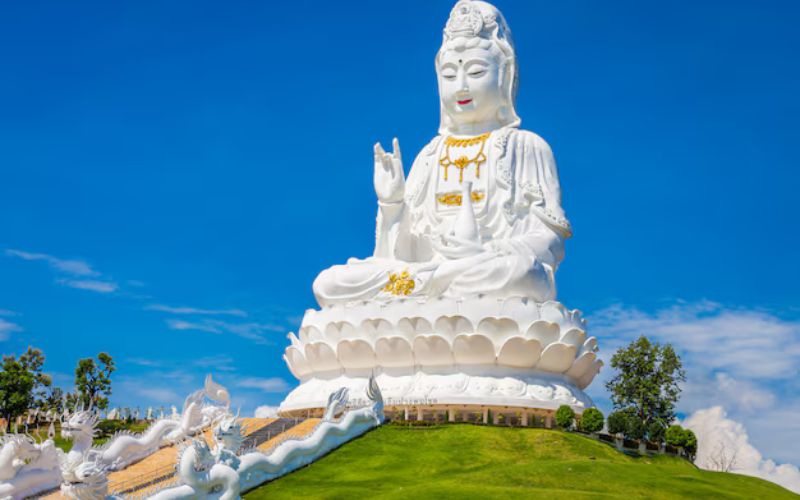 Giant white Guan Yin statue under blue sky at Wat Huay Pla Kang temple in Chiang Rai, Thailand