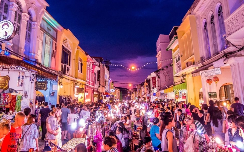 Brightly lit Sino-Portuguese buildings lining Phuket Walking Street, blending history with the lively atmosphere of the night market.