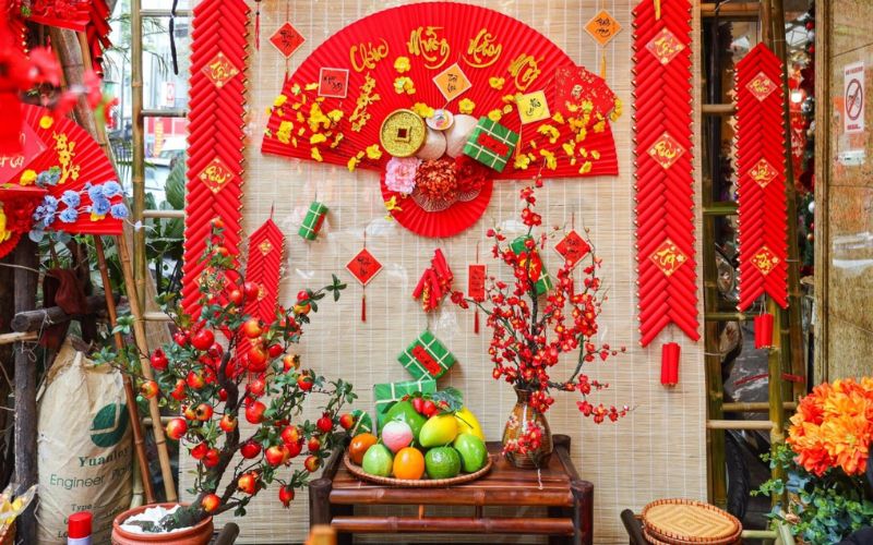 Vietnamese home decorated with red banners, flowers, and fruits for Tet holiday celebration.