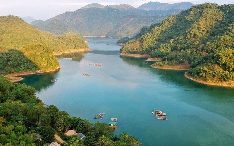 Panoramic view of Hoa Binh Lake in northern Vietnam, with turquoise waters winding between lush green hills and distant mountains