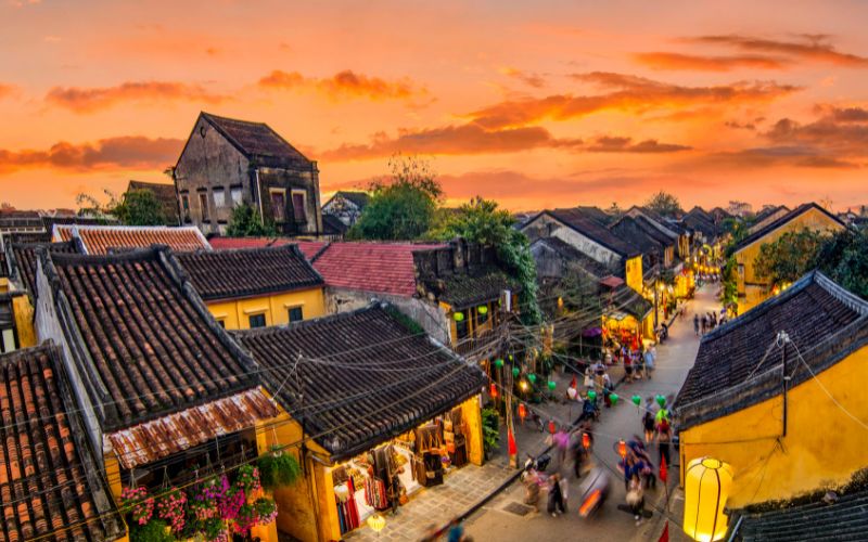 Hoi An Ancient Town in Vietnam at sunset with lantern-lit streets and yellow-painted heritage buildings
