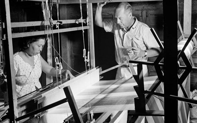 Jim Thompson instructs a Thai rural woman to weave silk