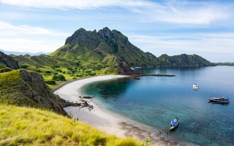 Padar Island in Komodo National Park, Indonesia, with green hills, white sand beaches, and turquoise water