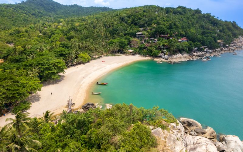 Aerial view of Haad Yuan Beach on Koh Phangan, Thailand — a peaceful, secluded bay with turquoise waters and lush green hills