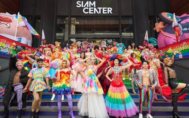 A kathoey artist dressed in rainbow-themed costume at a Pride performance.