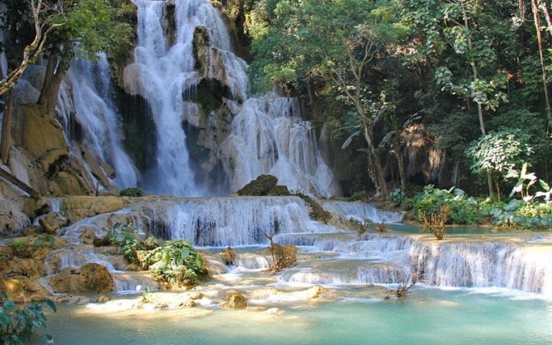 Cascading over limestone rocks into vibrant turquoise pools, Kuang Si Waterfall is a breathtaking natural wonder nestled in the lush forests near Luang Prabang.