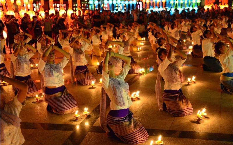 Loy Krathong Festival: Traditional Thai dancers performing surrounded by candlelight during the Loy Krathong Festival in Thailand