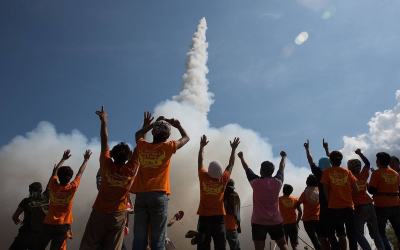Locals cheer as a traditional rocket soars into the sky