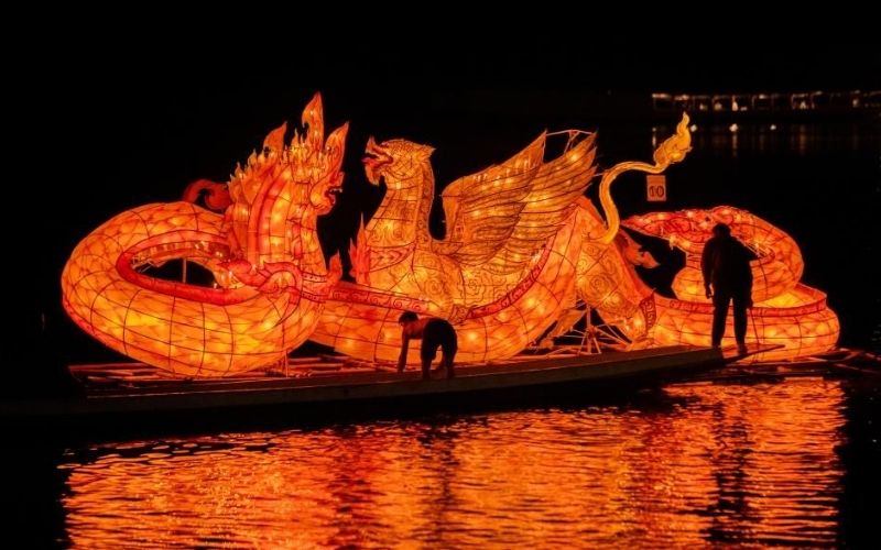 “Illuminated dragon-shaped lantern boat floating on the Mekong River during the Lai Heua Fai Festival in Luang Prabang, Laos.