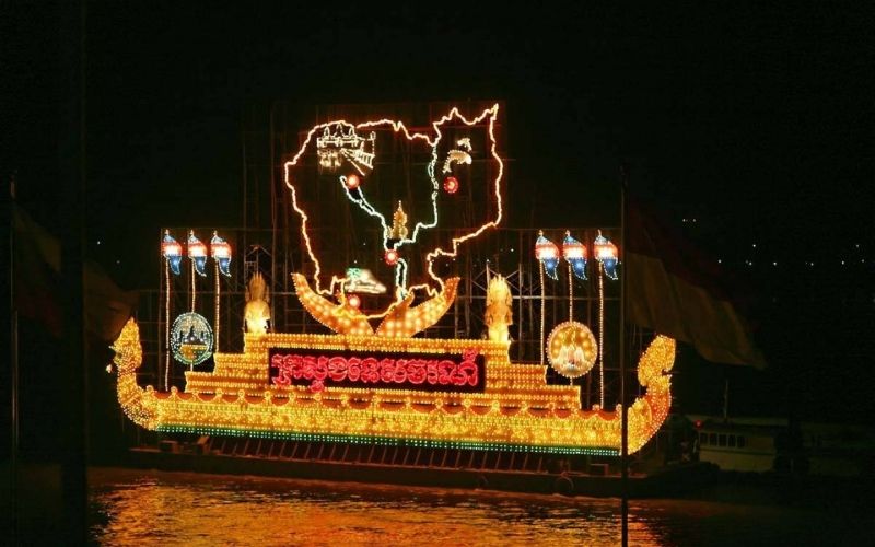 Illuminated lantern boat glowing at night on the river during Cambodia’s Bon Om Touk Water Festival