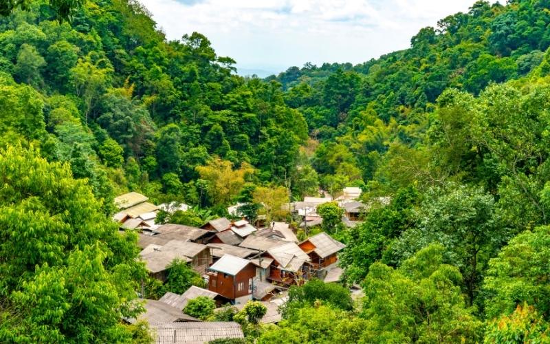 Scenic view of Mae Kampong Village in Chiang Mai, Thailand, nestled in lush green mountains with traditional wooden houses
