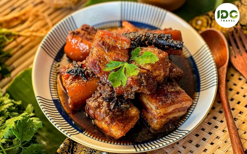 Moo hong, Phuket-style braised pork belly in dark soy sauce with cinnamon and star anise, served on a plate.