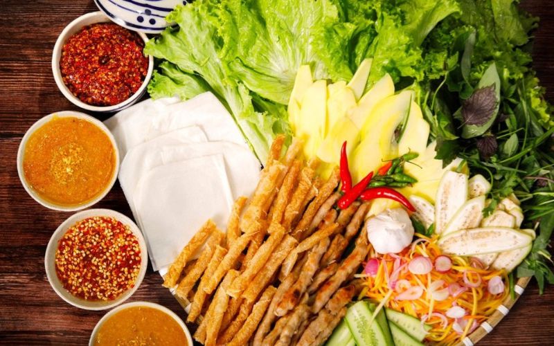 Ninh Hoa grilled pork sausage served with rice paper, fresh herbs, and dipping sauce in Khanh Hoa, Vietnam