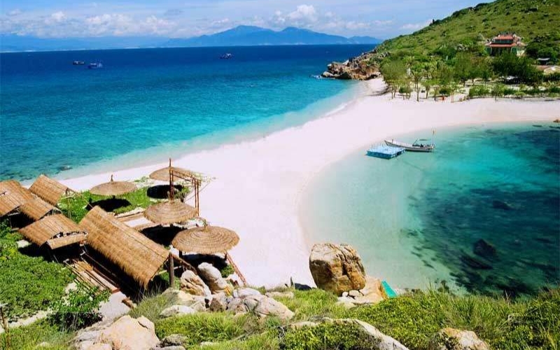 A scenic view of one of Nha Trang’s tropical islands, featuring crystal-clear turquoise water, white sand beaches