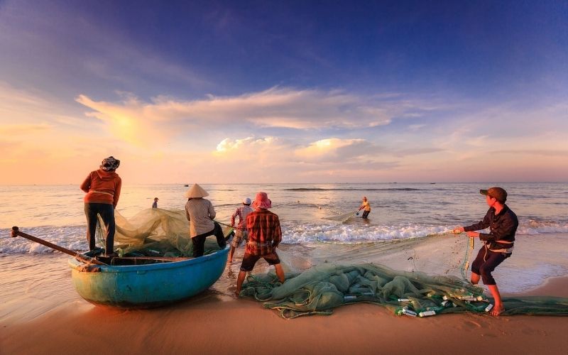 Fishermen pulling nets at sunrise in Nam O fishing village, Da Nang – a glimpse into authentic coastal life in Vietnam