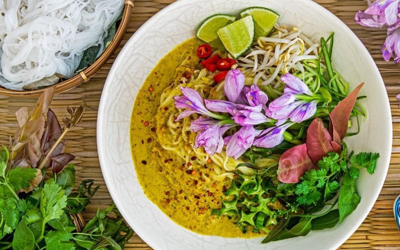 Nom Banh Chok, traditional Khmer curry noodle dish, served with fresh herbs and vegetables during Cambodia’s Bom Om Touk Festival