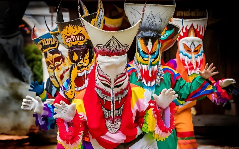 Performers wearing colorful, hand-crafted ghost masks and vibrant costumes during the Phi Ta Khon Festival, a unique celebration blending spiritual rituals with local folklore and artistic expression