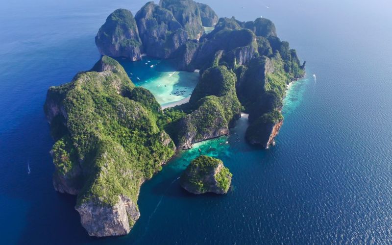 Aerial view of the Phi Phi Islands in Thailand, featuring lush green cliffs and turquoise waters