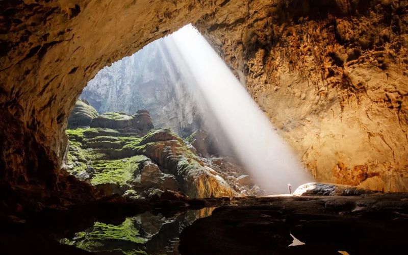 Interior of Phong Nha Cave showing illuminated stalactites, stalagmites, and wooden walkways inside the cave