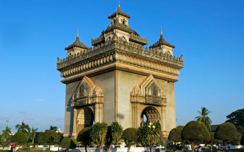 Patuxai, the famous Victory Monument in central Vientiane, Laos, featuring striking architecture that blends French style with traditional Lao motifs, under a clear blue sky.