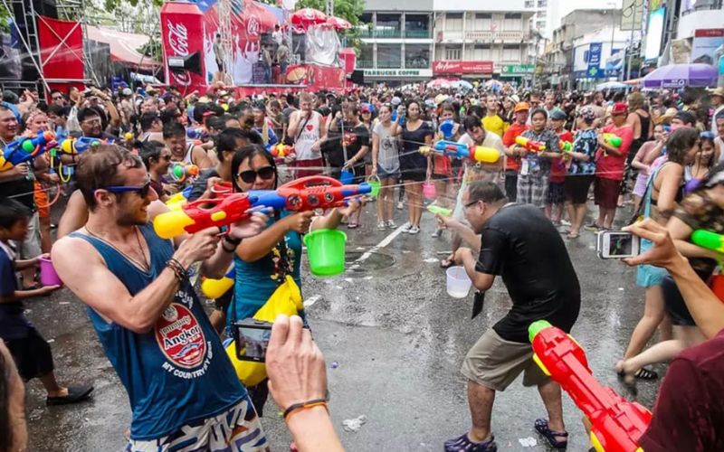 Crowds of locals and tourists in a street water fight with water guns and buckets during Songkran Festival in Pattaya, Thailand