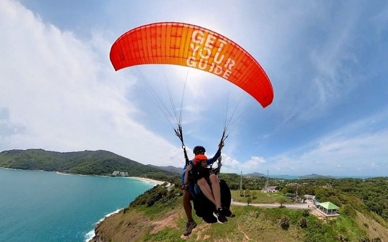 Paragliding above the Andaman Sea with panoramic coastal views in Phuket, Thailand.