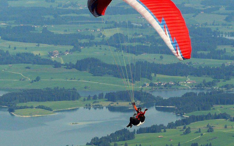 Solo paraglider flying over lakes and farmland near Phnom Penh, Cambodia.