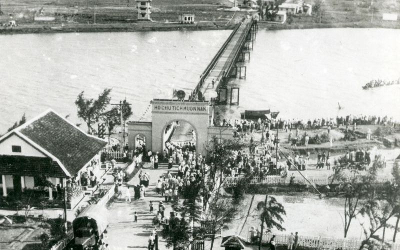 Historic photo of Quang Tri Province, Vietnam, showing an old bridge and crowded riverside scene