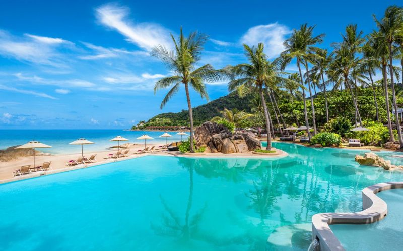 Tropical beach resort with palm trees, infinity pool, and ocean view, perfect for relaxing vacations in Thailand