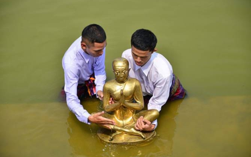 Locals perform a river ceremony to summon the spirit of Phra Upakhut, marking the spiritual beginning of the Phi Ta Khon Festival in Dan Sai, Thailand