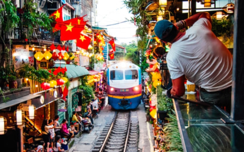 A train squeezes past cafés and homes just inches away from tourists at Hanoi’s famous Train Street, one of the city's most thrilling and unforgettable experiences.