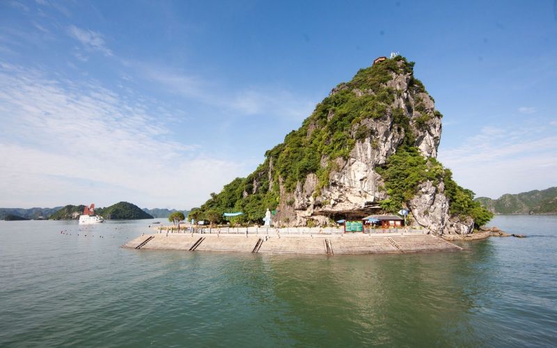 Ti Top Island in Ha Long Bay seen from the water, showing the limestone hill, pier, and starting point for the viewpoint climb