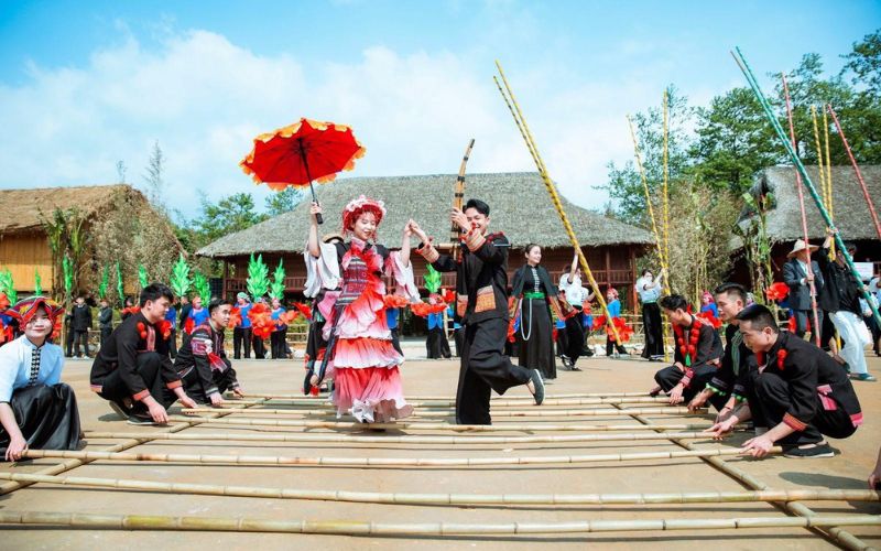 Ethnic minority people in Lào Cai, Vietnam performing traditional bamboo dance in colorful costumes during a cultural festival