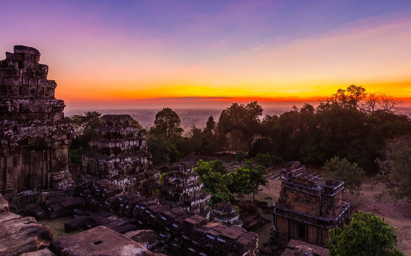 A breathtaking sunset casts a warm glow over Angkor Wat, creating the perfect romantic backdrop for couples exploring the ancient beauty of Siem Reap.