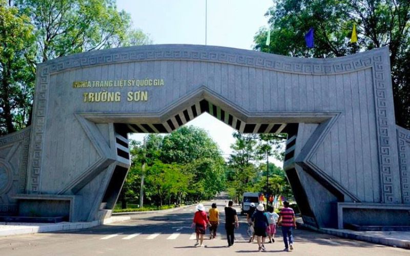 Entrance gate of Truong Son National Cemetery in Quang Tri, Vietnam, with visitors walking inside