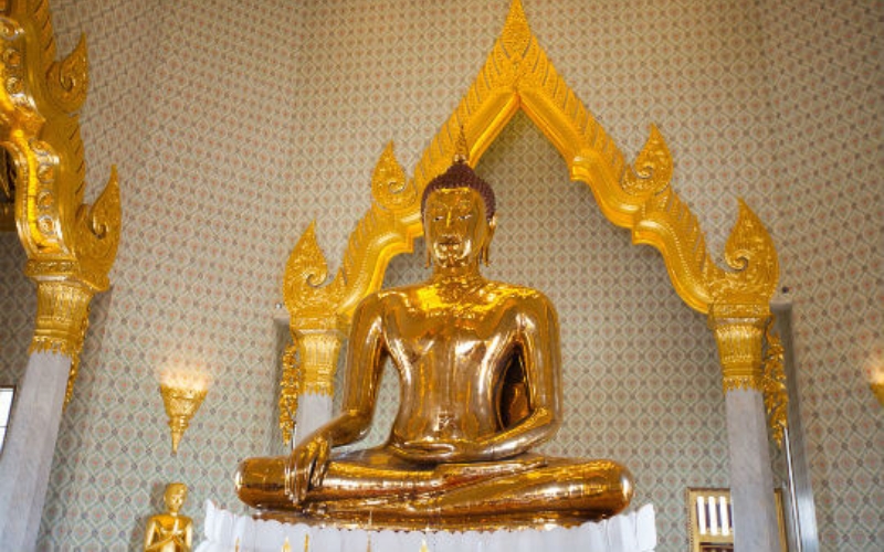 A close-up view of the world’s largest solid gold Buddha statue, glowing under temple lights at Wat Traimit in Bangkok.