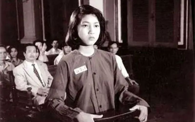 A dedicated memorial exhibit for the national heroine Vo Thi Sau. It features a prominent portrait of the young revolutionary, surrounded by commemorative wreaths and fresh white flowers. Below the portrait is a biographical display detailing her bravery and her legacy as a symbol of youthful patriotism in Vietnam.