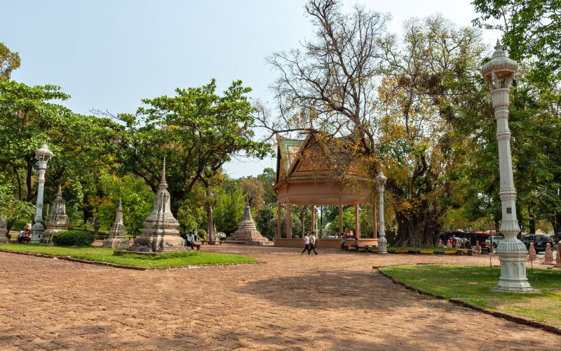 Wat Phnom temple complex surrounded by trees and open courtyard in central Phnom Penh.